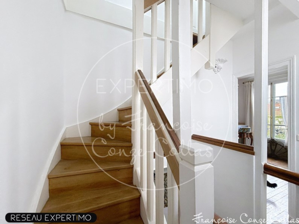Wooden staircase leading to the upper floor of a millstone house in Chaville.