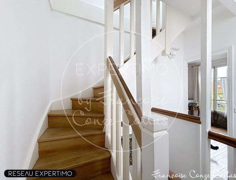 Wooden staircase leading to the upper floor of a millstone house in Chaville.