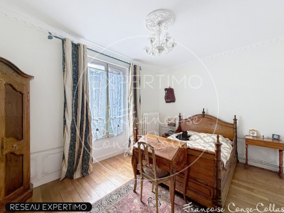 Room in a millstone house with a wooden bed and a desk, windows overlooking the outside.