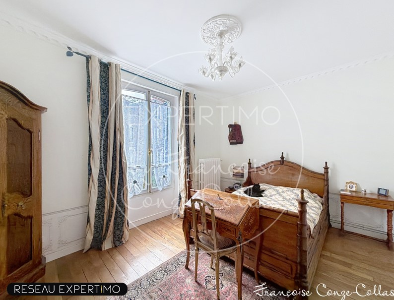 Room in a millstone house with a wooden bed and a desk, windows overlooking the outside.