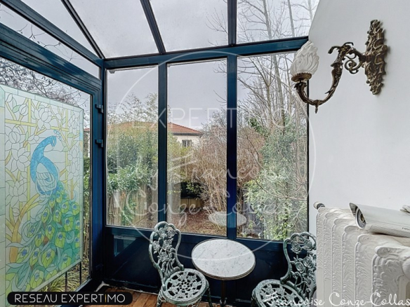 Veranda of a millstone house with stained glass decoration and wrought iron furniture.