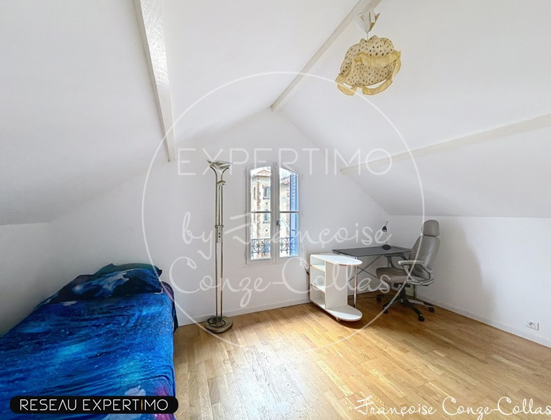 Attic room with a bed and a desk, natural light in Chaville.