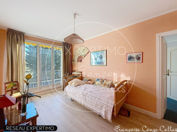 Chambre d'un appartement familial à Versailles avec lit et fenêtre donnant sur un balcon.