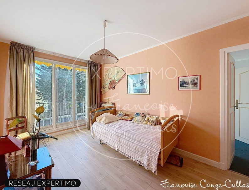 Chambre d'un appartement familial à Versailles avec lit et fenêtre donnant sur un balcon.