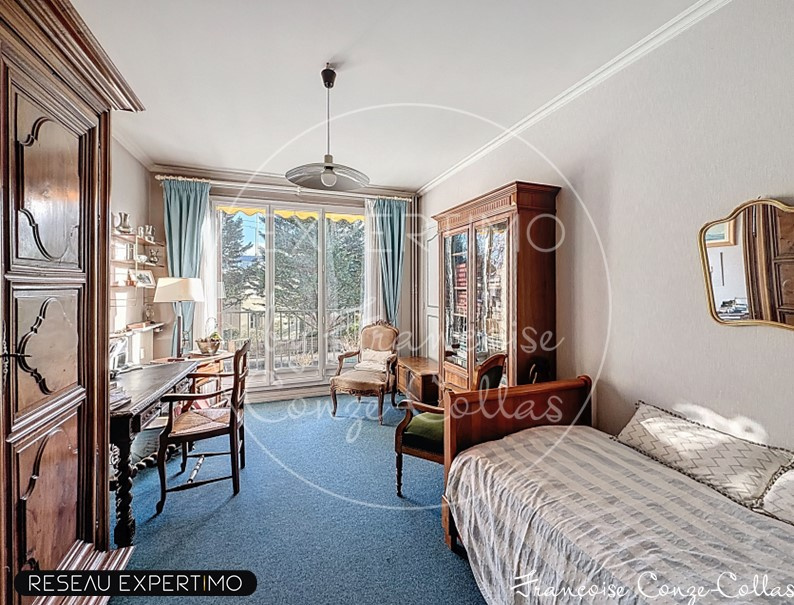 Chambre d'un appartement familial à Versailles avec mobilier classique et balcon.
