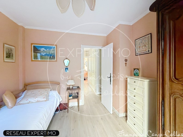 Chambre d'un appartement familial à Versailles, avec un lit simple et des murs peints en rose.