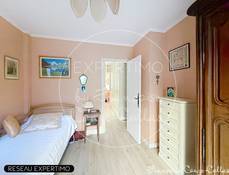 Chambre d'un appartement familial à Versailles, avec un lit simple et des murs peints en rose.