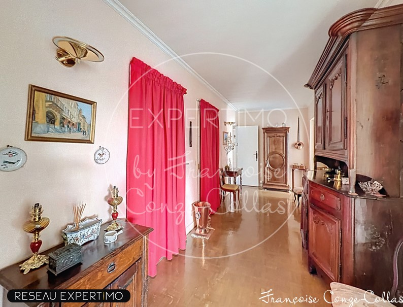 Entrée d'un grand appartement familial avec des murs clairs et des rideaux rouges.