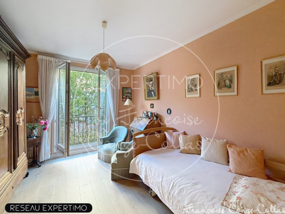 Chambre d'un appartement familial à Versailles avec un balcon et des murs peach.