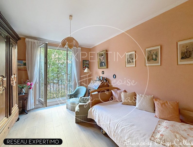 Chambre d'un appartement familial à Versailles avec un balcon et des murs peach.
