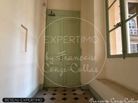 Entrée d'un appartement avec porte verte et carrelage noir et blanc.
