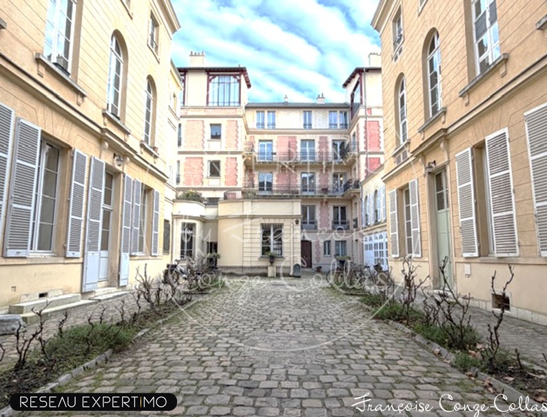 Cour intérieure d’un immeuble à Versailles Cour intérieure d'un immeuble historique à Versailles avec pavés et façades anciennes.