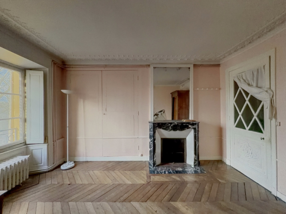 Intérieur d'un appartement de charme à Versailles avec parquet et cheminée en marbre.