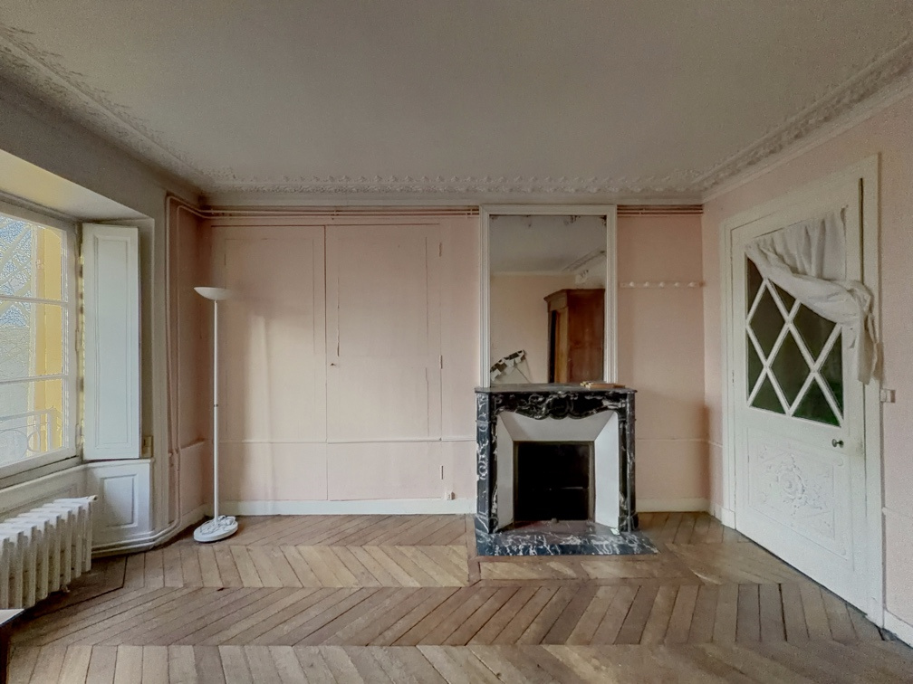 Appartement de charme à Versailles Intérieur d'un appartement de charme à Versailles avec parquet et cheminée en marbre.