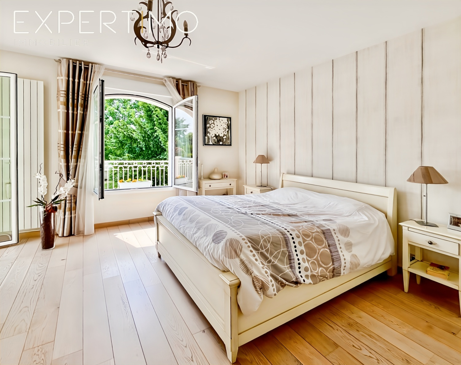 Chambre haut de gamme à Sainte-Geneviève-des-Bois Chambre lumineuse avec lit double et accès à un balcon, décorée avec des murs en bois et un sol en parquet.