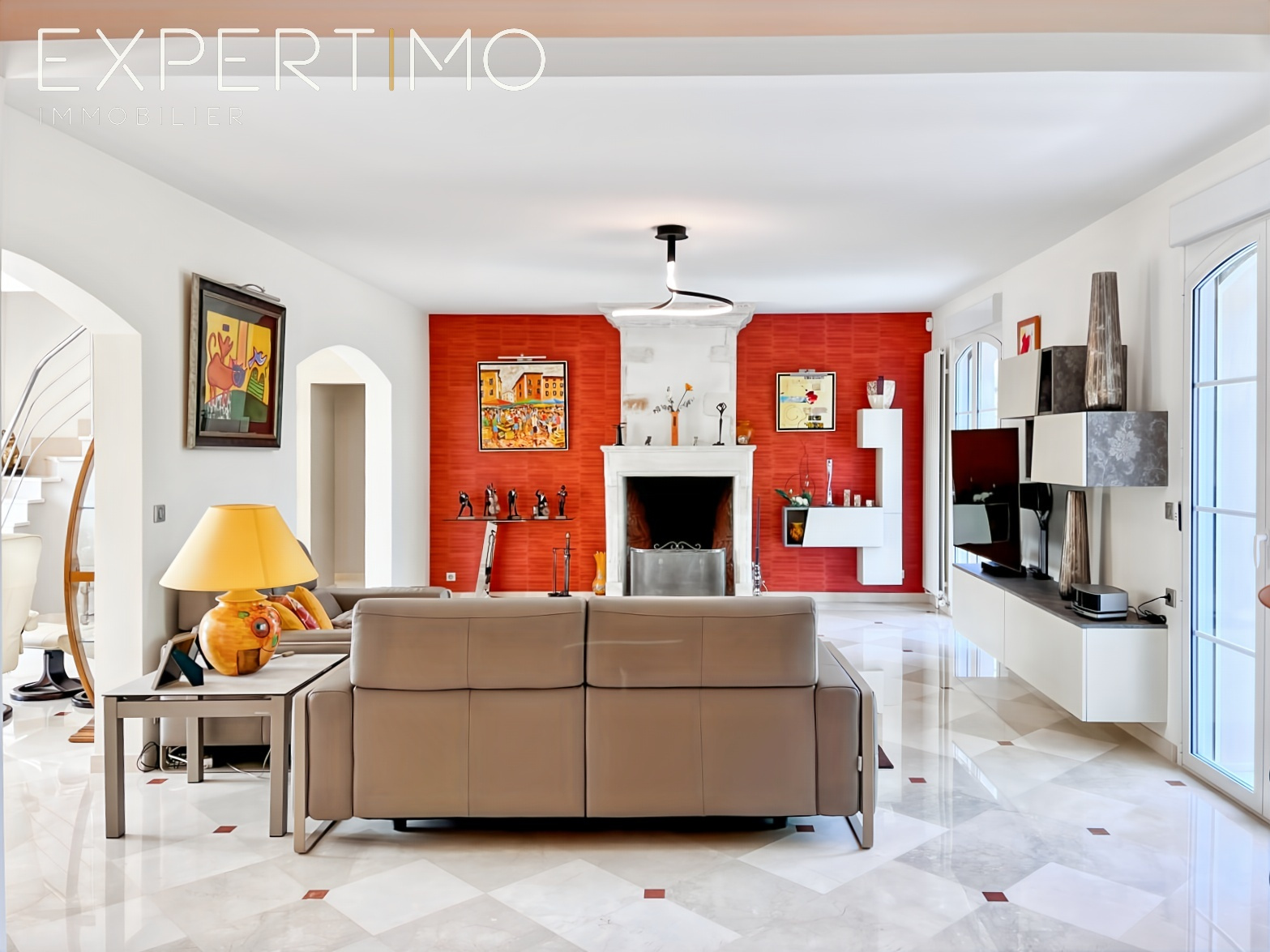 Salon d’une propriété de caractère Intérieur d'une propriété haut de gamme avec un salon lumineux, sol en marbre et cheminée.
