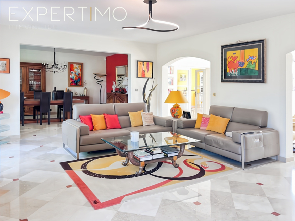 Intérieur d'une propriété haut de gamme avec un salon lumineux, canapé moderne et décoration colorée.