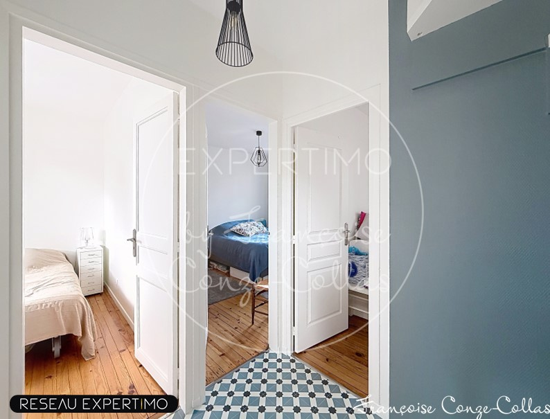 Intérieur d'une maison rénovée avec deux chambres et un couloir lumineux.