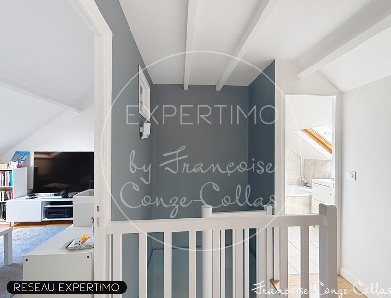 Intérieur d'une maison rénovée avec un escalier et un espace de vie lumineux.