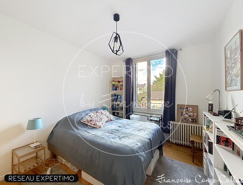 Chambre lumineuse avec lit double et bibliothèque, fenêtres avec vue sur l'extérieur.