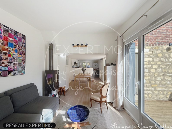 Intérieur d'une maison rénovée avec un salon lumineux et un espace salle à manger.