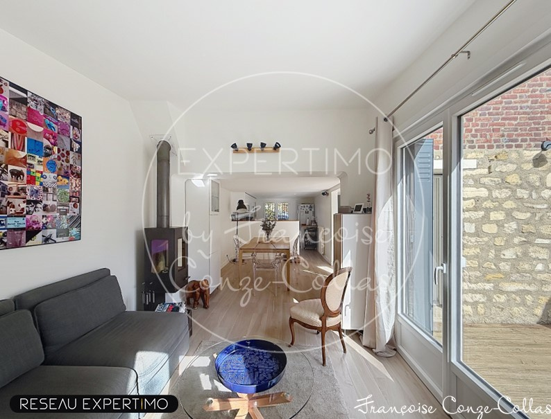 Intérieur d'une maison rénovée avec un salon lumineux et un espace salle à manger.
