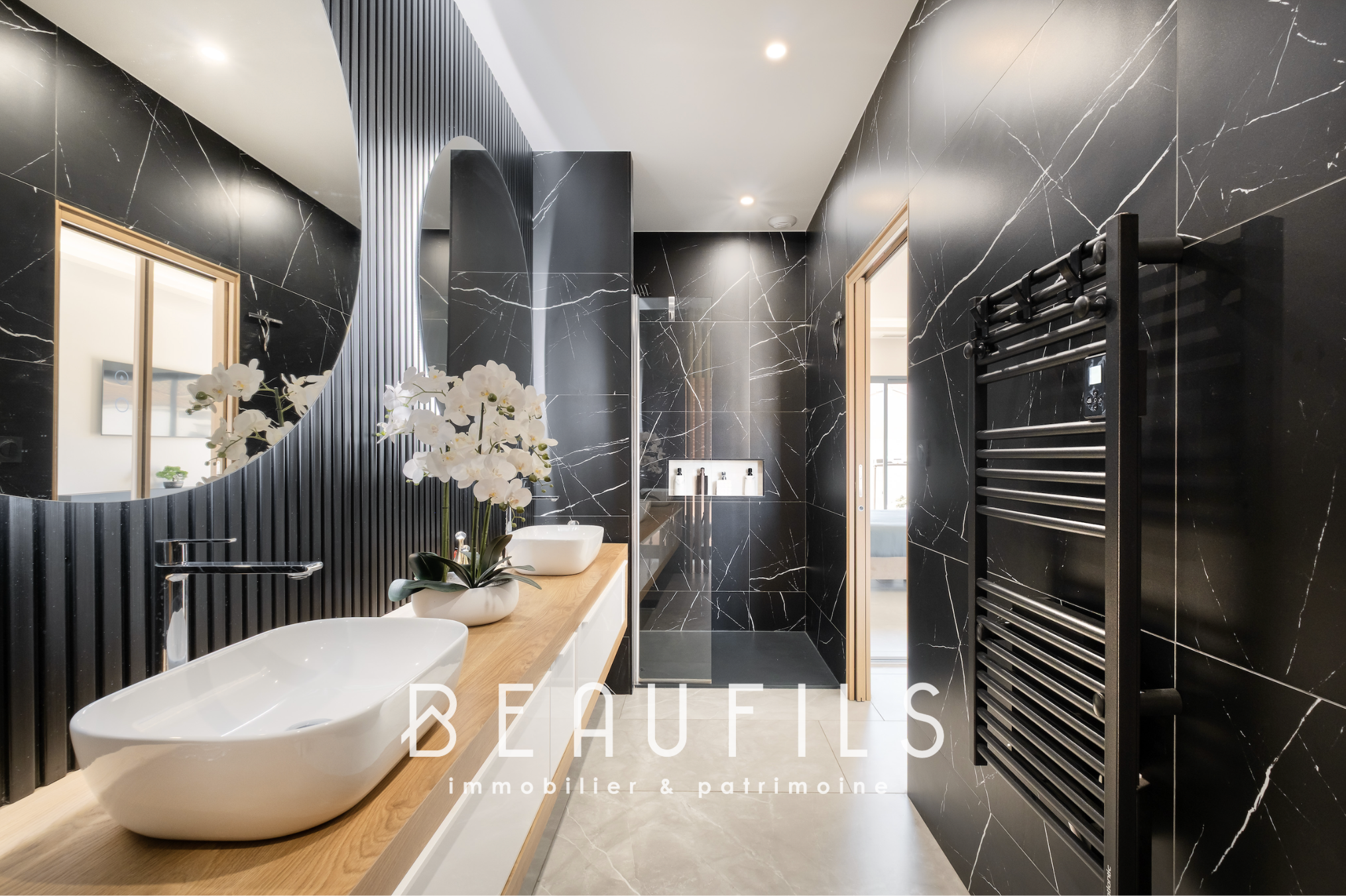 Salle de bain contemporaine Salle de bain moderne avec murs en marbre noir et double vasque, éclairage naturel