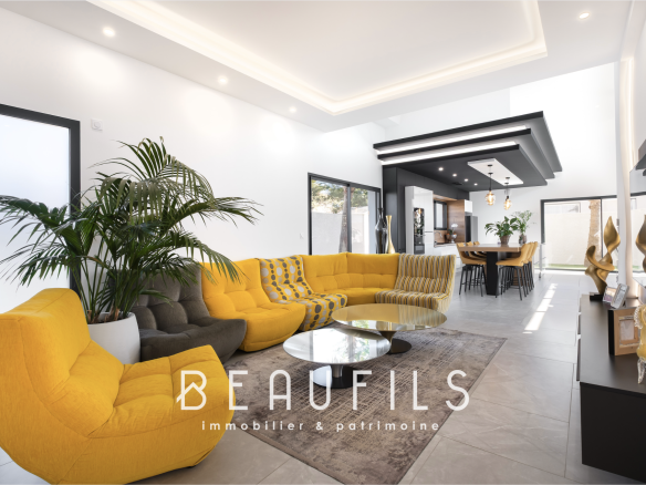 Intérieur d'une villa californienne moderne avec un salon lumineux et une grande cuisine ouverte.