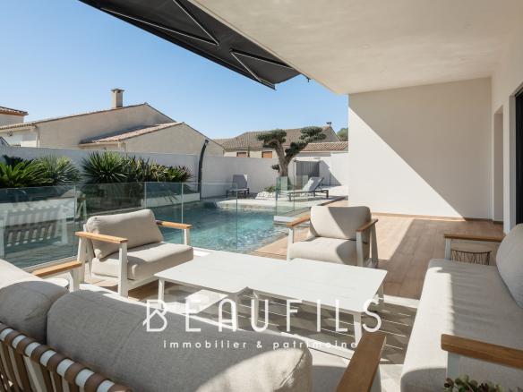 Terrasse d'une villa californienne avec mobilier moderne et piscine, située à Vias.