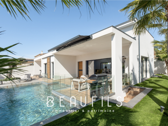 Villa californienne de plain-pied avec piscine et terrasse, entourée de palmiers.