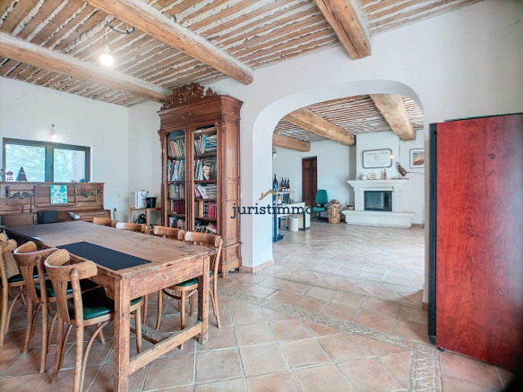 Interior of a property with a wooden dining room and a living room with a fireplace.