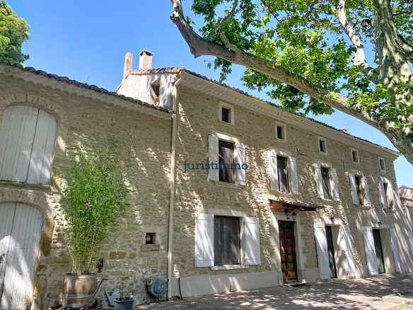 Stone property with windows and shutters, surrounded by trees, in Provence.