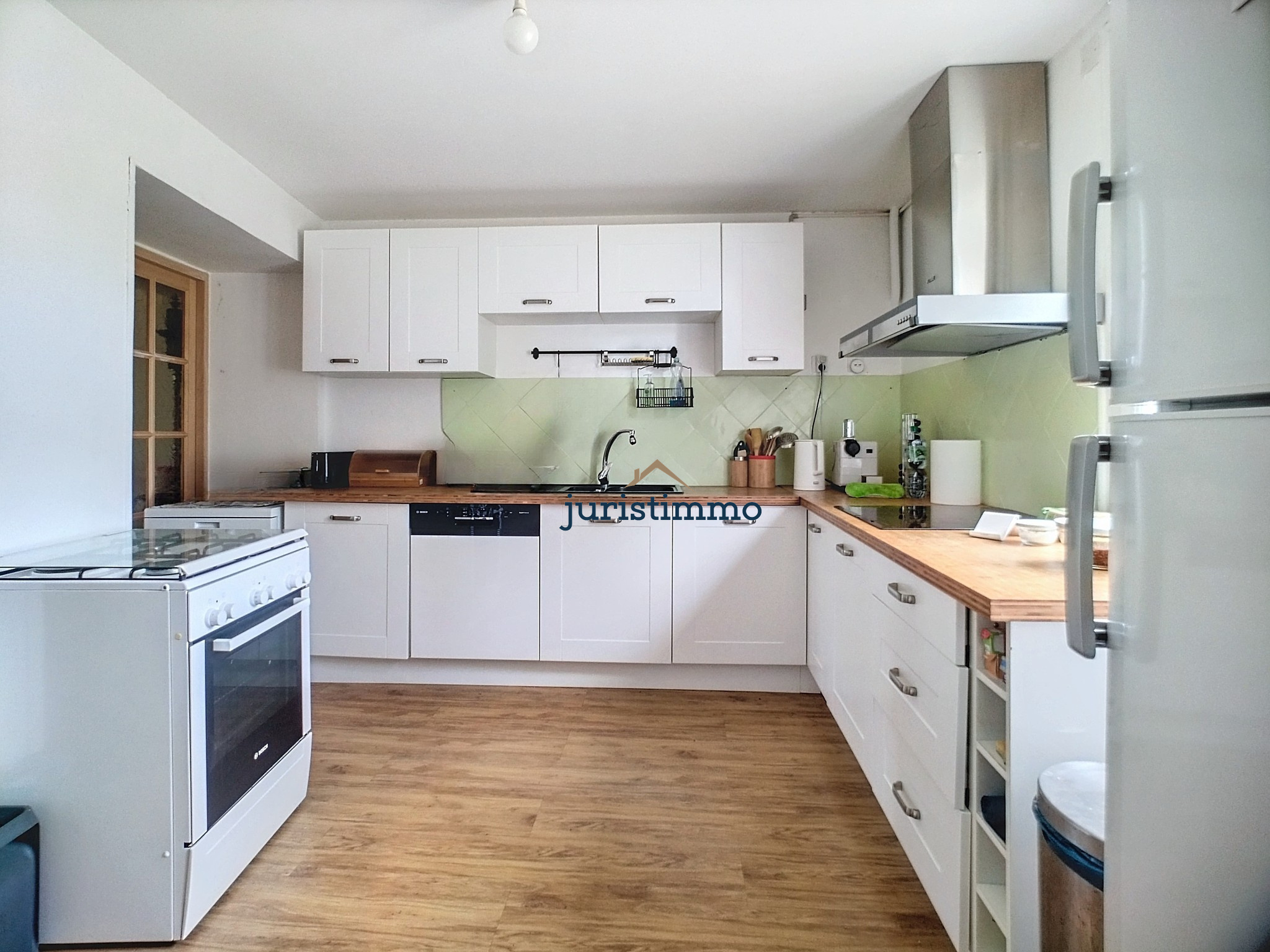 Kitchen of a property in Provence Modern and bright kitchen in a property in Provence with white furniture and wooden worktop.