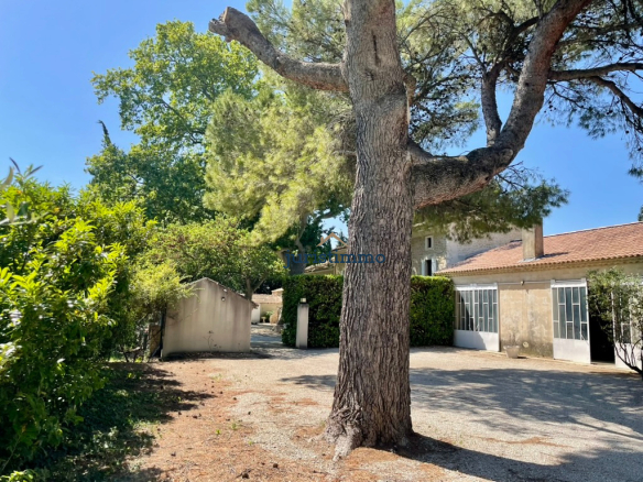 View of a property surrounded by trees and greenery in Camaret-sur-Aigues.