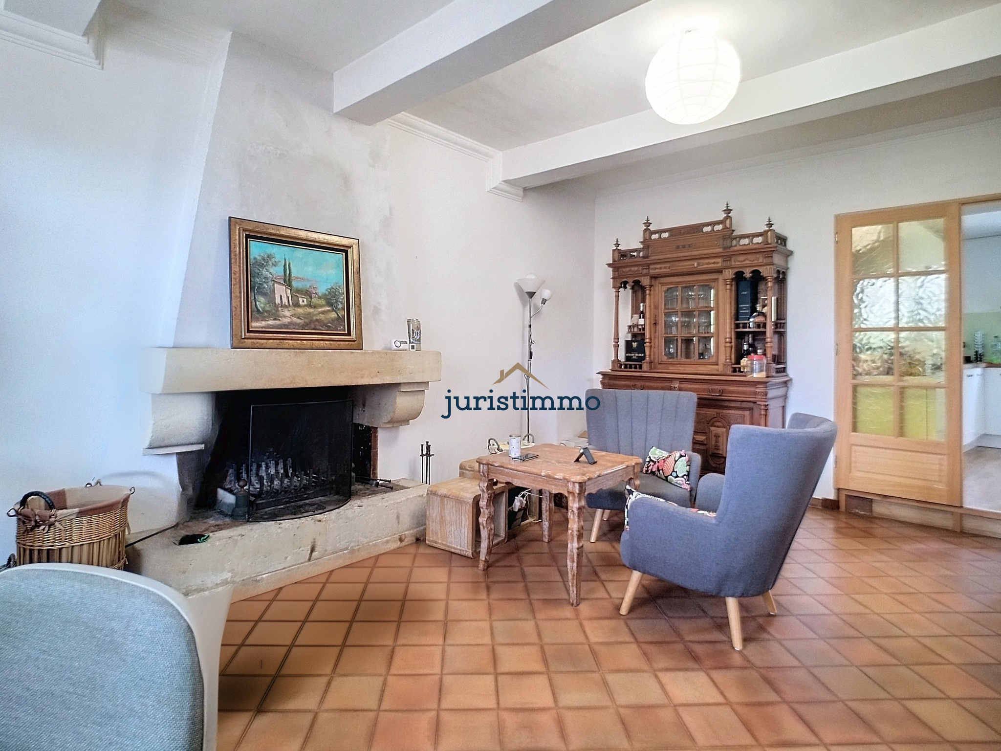 Interior of an elegant property in Provence Interior of a house with fireplace, coffee table and armchairs, simple and warm decor.
