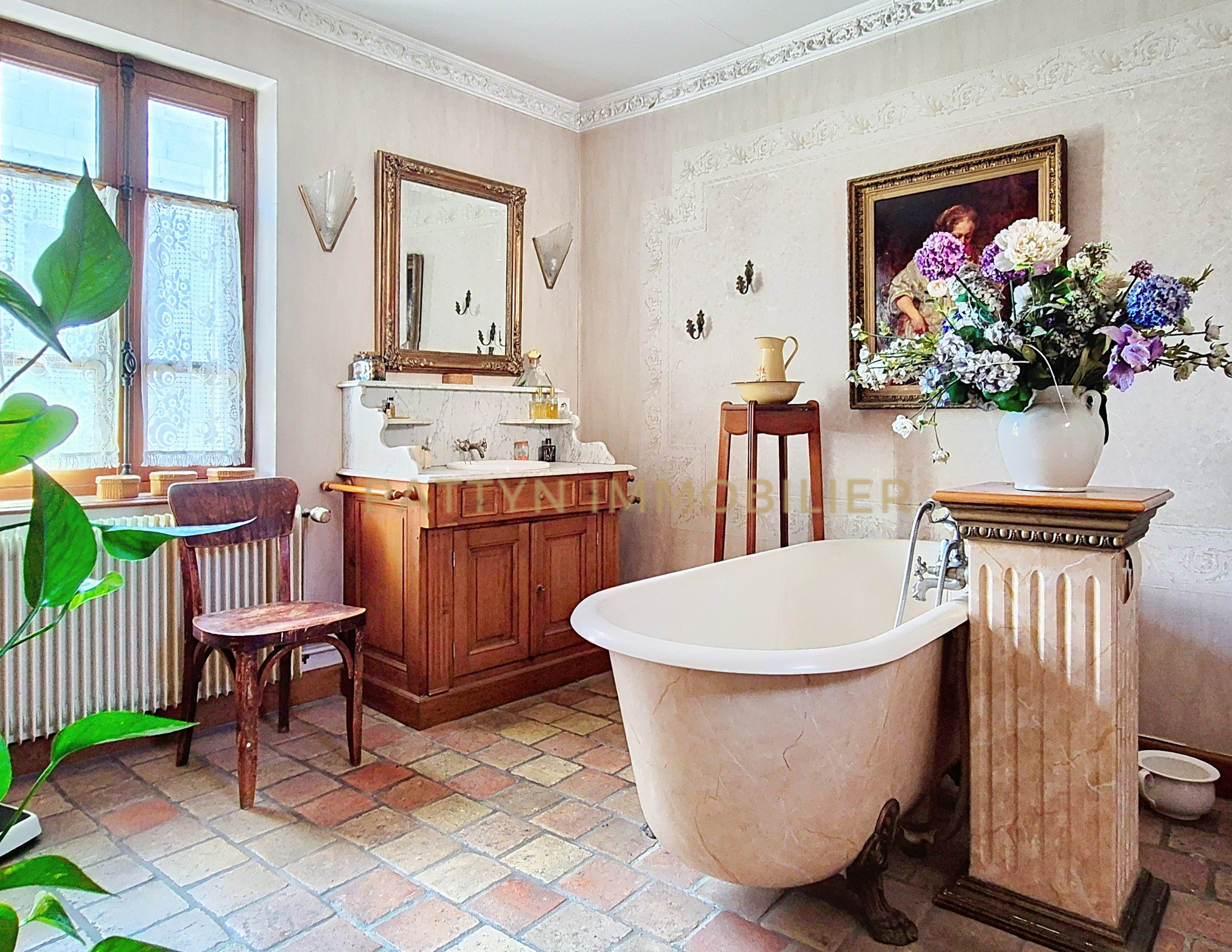 Elegant bathroom in Tramoyes Bathroom with freestanding bathtub, mirror and floral decoration, in a house in Tramoyes.