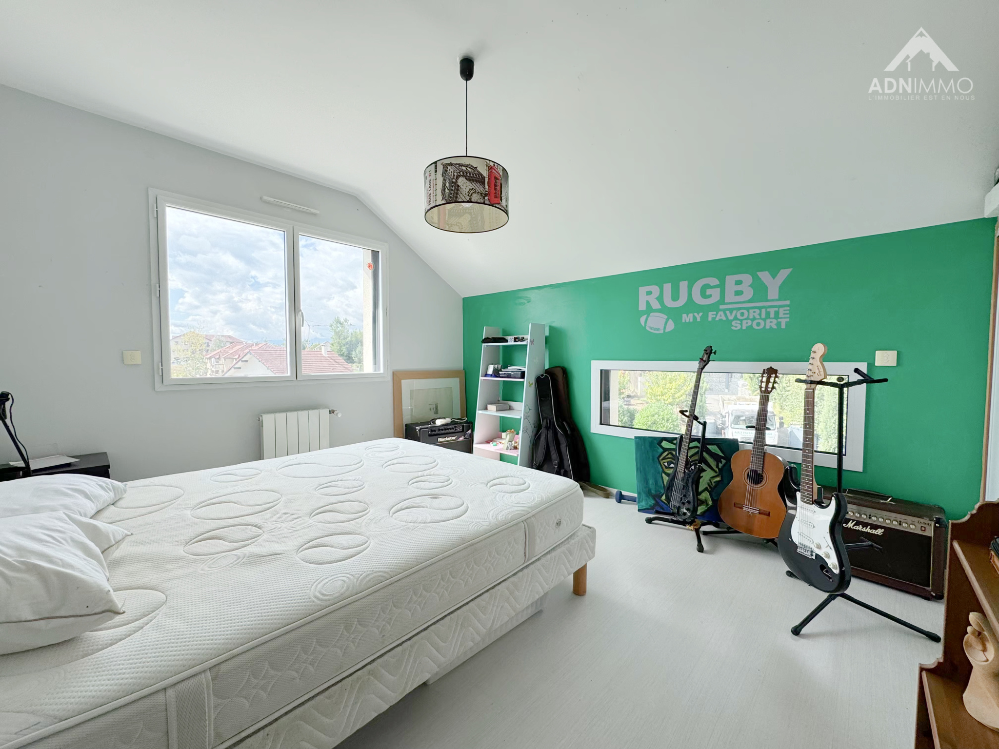 Chambre d'une maison avec un mur vert et des instruments de musique.