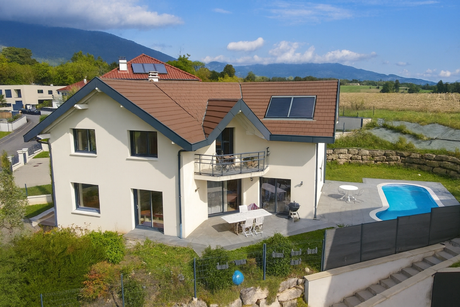 Maison individuelle de 280 m2 avec piscine à Chevry, vue sur la montagne.