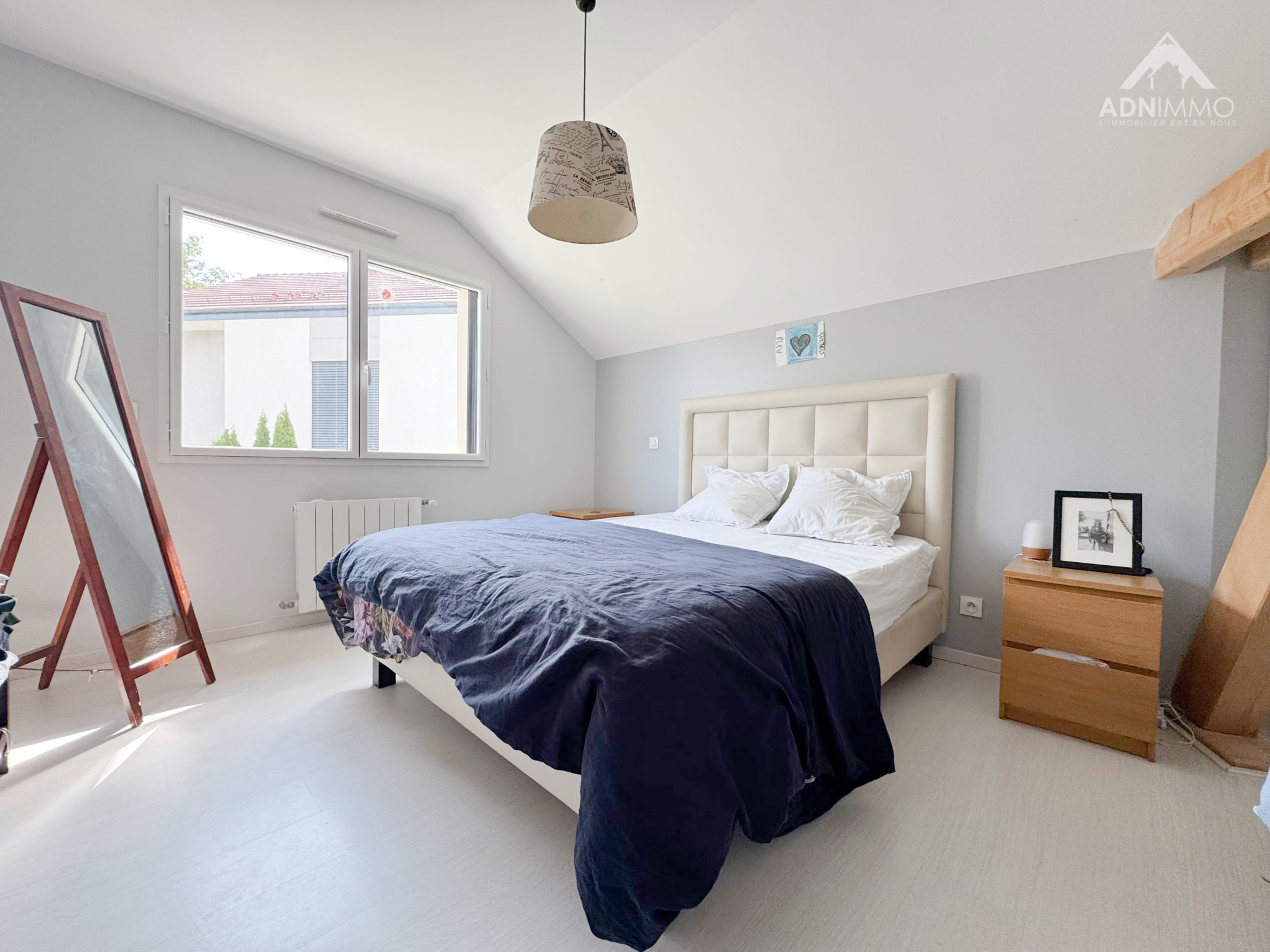 Chambre d'une maison individuelle à Chevry, avec lit double et fenêtre lumineuse.
