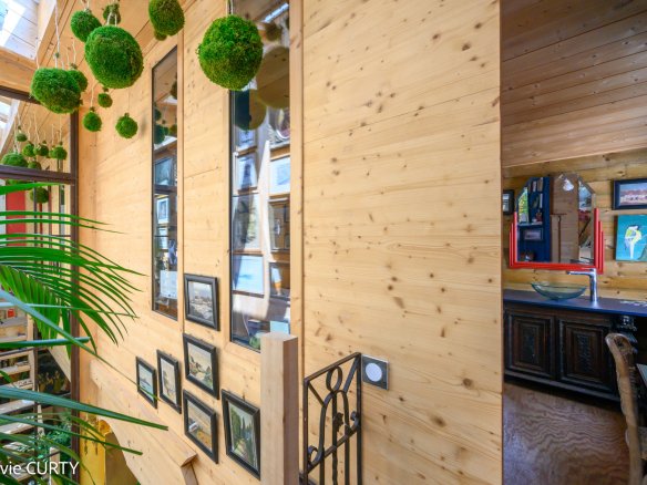 Intérieur d'une maison de caractère avec murs en bois et décorations artistiques.