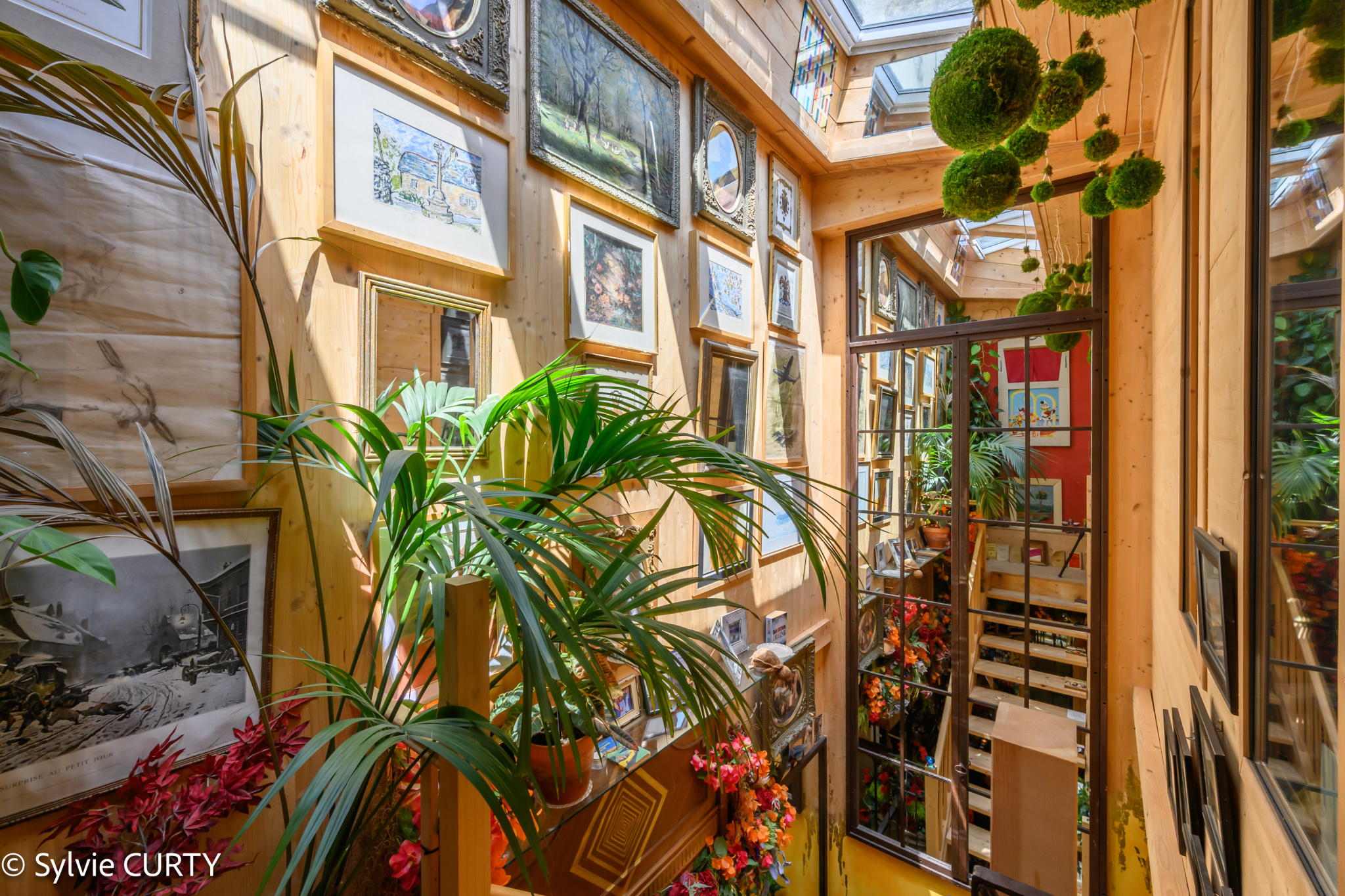 Intérieur d’une maison de caractère à La Rochelle Intérieur d'une maison de caractère avec des plantes et des œuvres d'art accrochées aux murs.