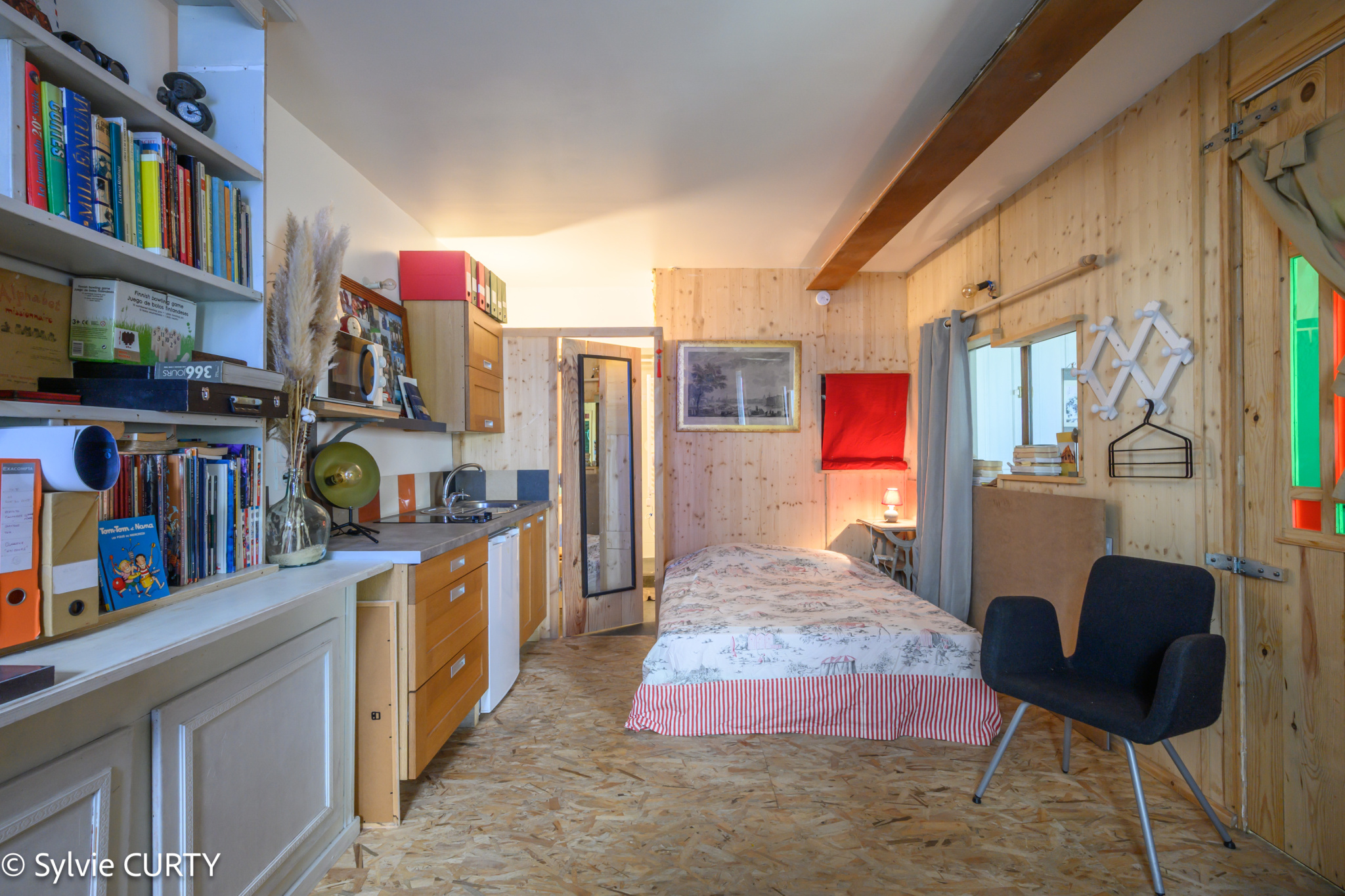 Intérieur d’une maison de caractère à La Rochelle Intérieur d'une maison de caractère avec cuisine et coin nuit, murs en bois et décoration artistique.