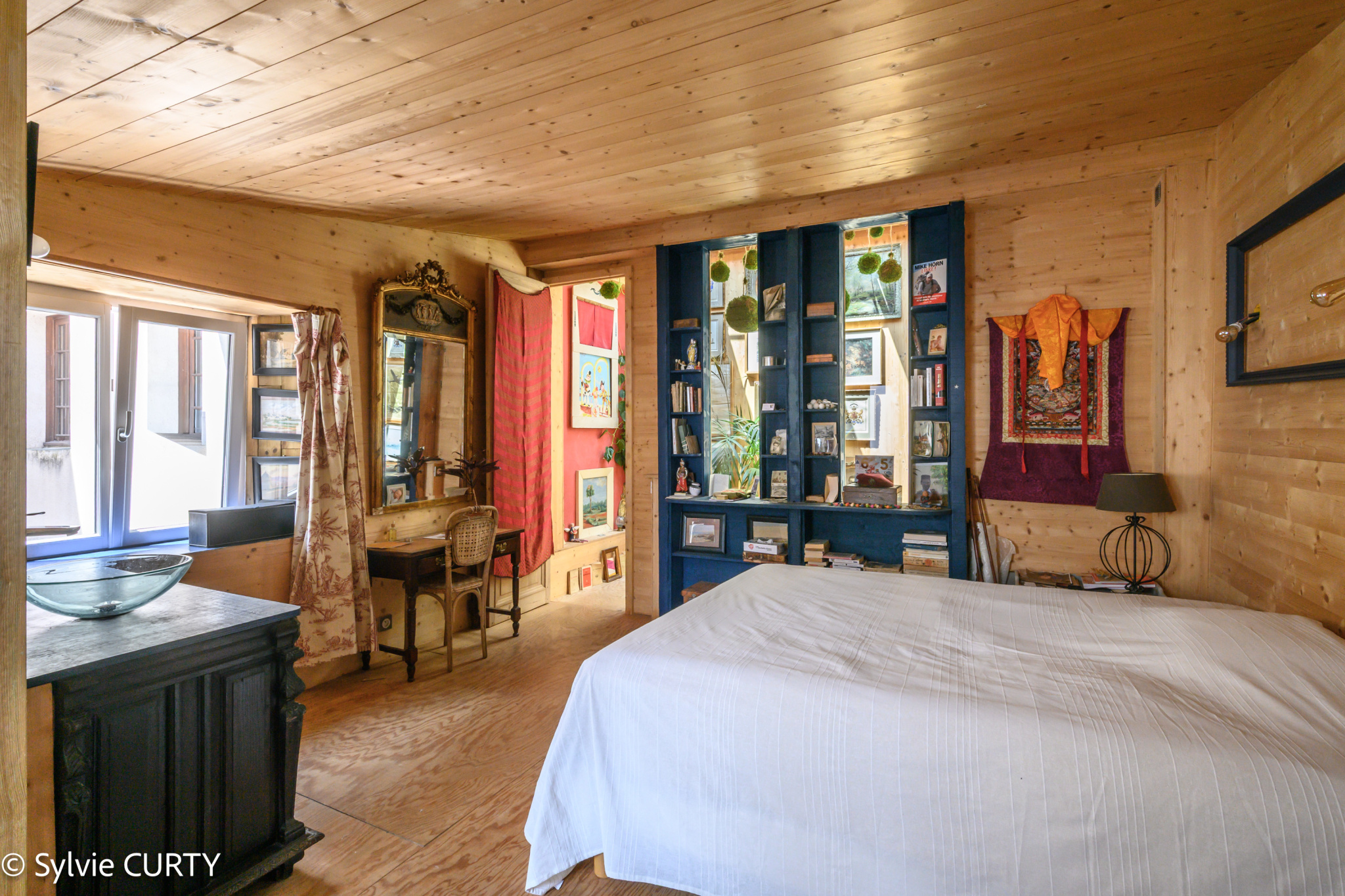 Chambre d’une maison historique à La Rochelle Chambre d'une maison de caractère avec murs en bois et décoration artistique à La Rochelle.