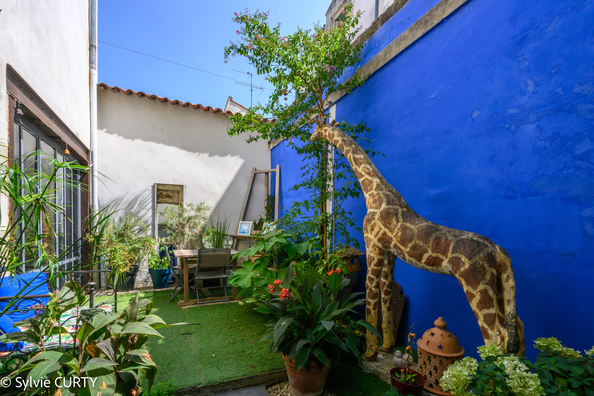 Jardin d’une maison de caractère à La Rochelle Jardin avec une girafe en décoration et des plantes, maison de caractère à La Rochelle.
