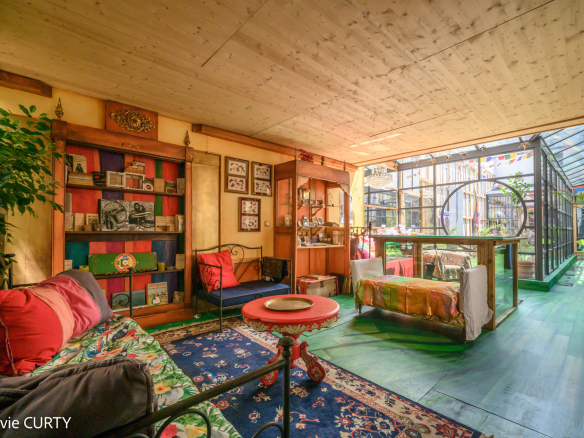 Intérieur d'une maison de caractère avec salon coloré et espace lumineux.