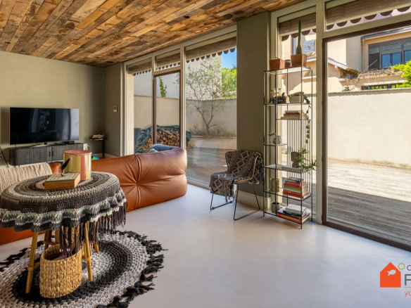 Intérieur d'une maison rénovée avec un salon moderne et un accès à une terrasse.