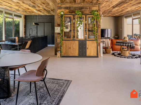 Intérieur d'une maison rénovée avec un salon moderne et une cuisine ouverte.