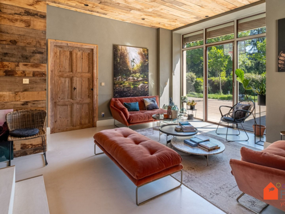 Intérieur d'une maison rénovée avec salon moderne et fenêtres donnant sur le jardin.