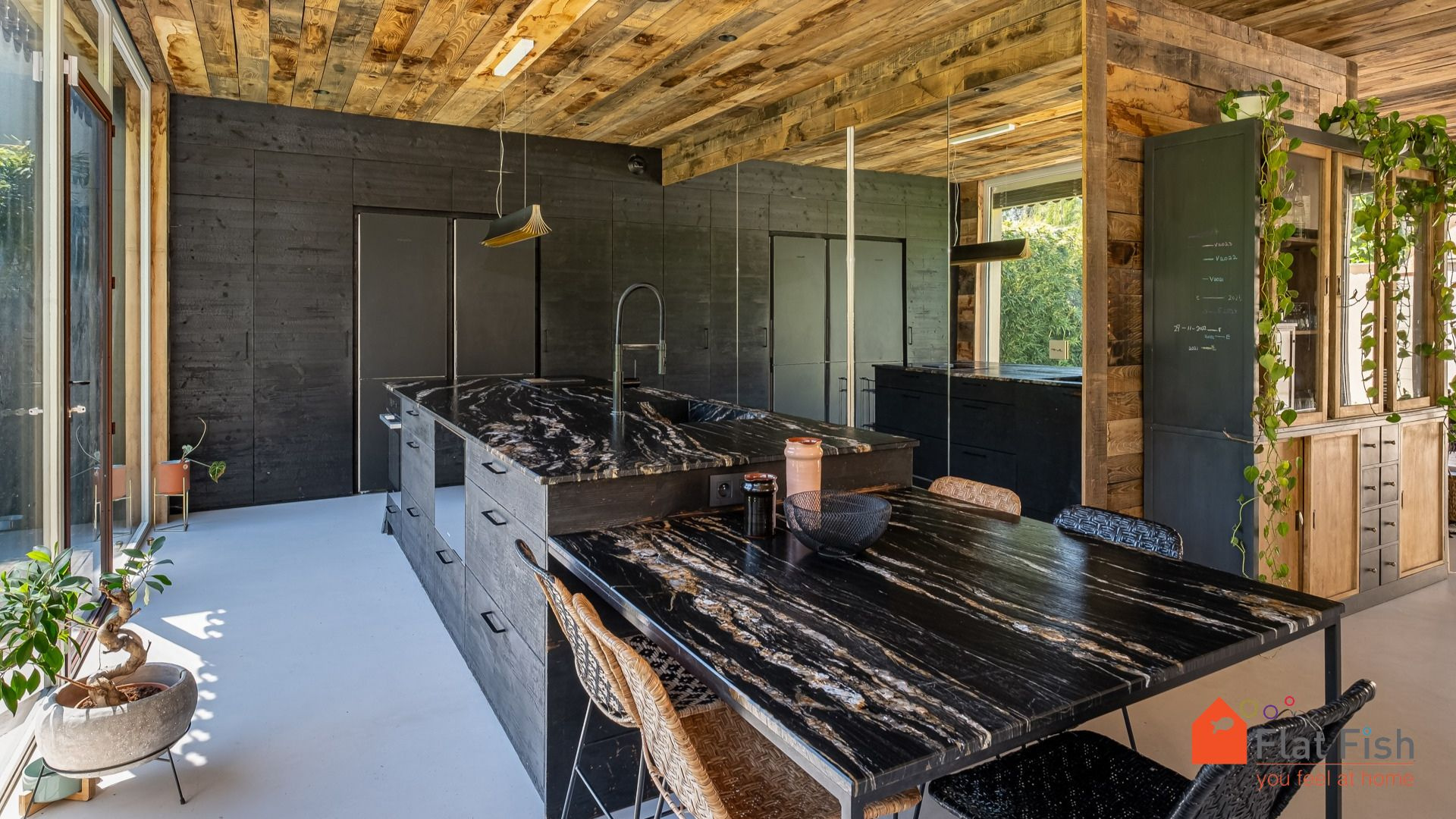 Cuisine contemporaine dans une maison rénovée Cuisine moderne avec îlot central en marbre et murs en bois, dans une maison rénovée.