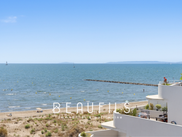 Panoramic sea view from an apartment in Grau-du-Roi, with beach and sailboats in the distance.